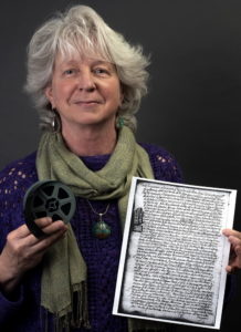 headshot of Dale Brenneman holding a photostat and microfilm reel
