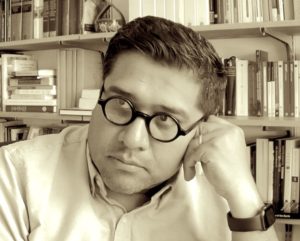 black and white photo of Obed Lira in front of bookshelves