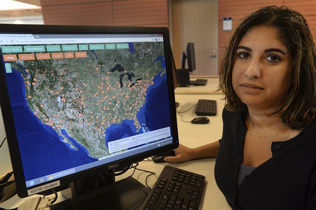 Photo of Roopika Risam in front of a computer monitor showing a marked up map of the United States